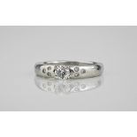 A platinum and diamond ring, the central brilliant cut diamond, approx. 0.33ct, over shoulders inset