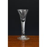 A mid-18th century trumpet airtwist wine glass, c.1750, the drawn trumpet bowl on an incised,