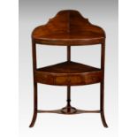 A George III mahogany corner washstand, the shaped back over a later bowfront shelf and conforming