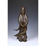 A Chinese silver wire inlaid bronze figure of Guanyin, 18th / 19th century, mid-brown patination,