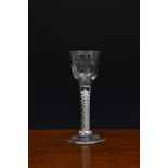 A mid-18th century engraved air twist wine glass, c.1750-60, the ogee bowl with slightly everted rim