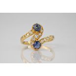 A French mid-century 18ct gold, cabochon sapphire and diamond twist ring, the ring centred by an S-
