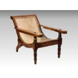 A Burmese teak plantation chair, late 19th / early 20th century, the scroll back and concave caned