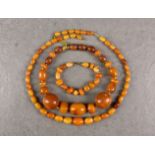An egg yolk amber necklace, early to mid-20th century, with graduated 11mm. to 21mm. ovoid beads