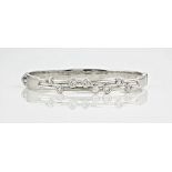 A 9ct white gold and diamond hinged bangle, by Martin & Martin of Guernsey, the split bar setting