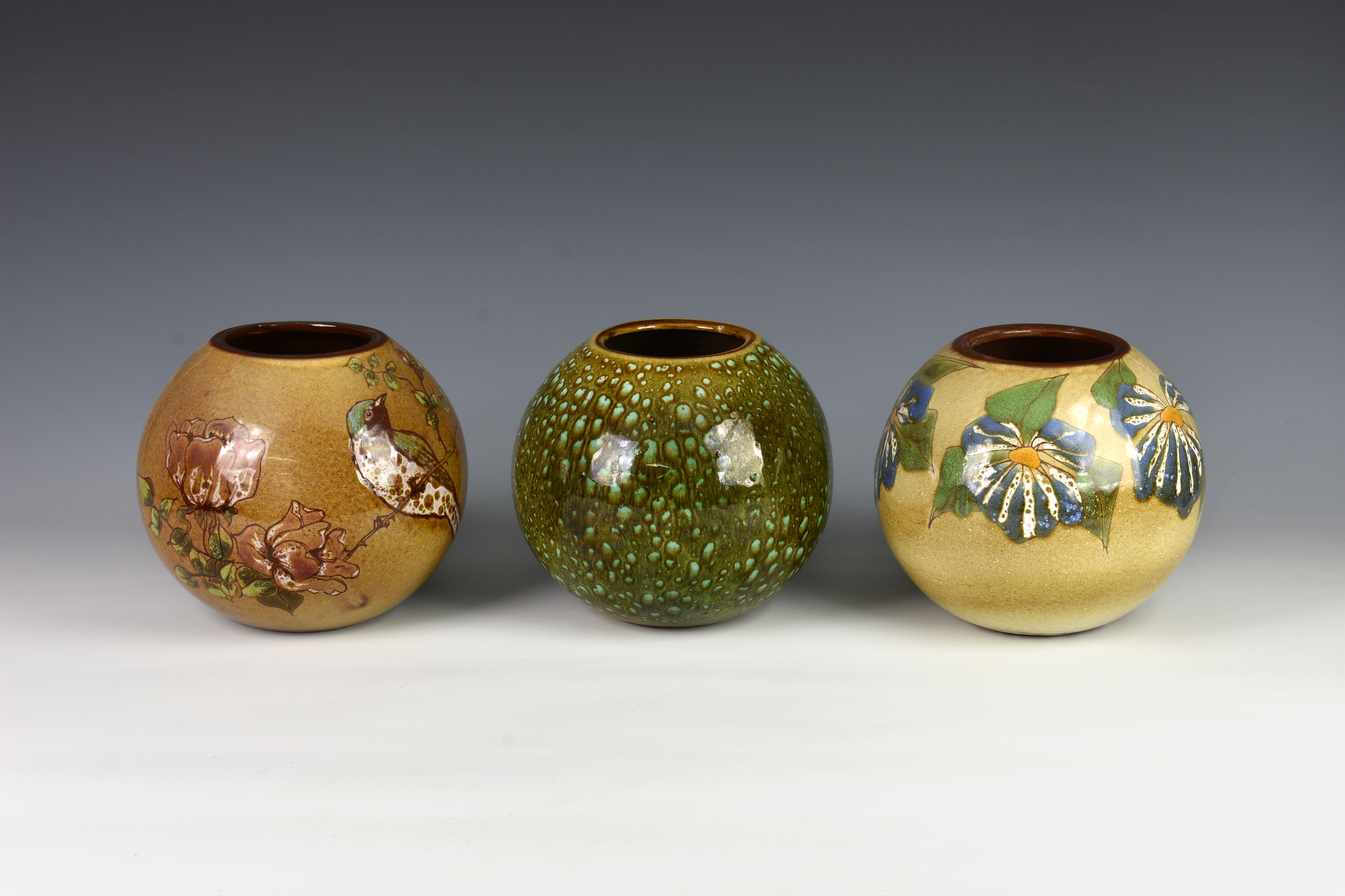 Three Guernsey pottery vases, each of globular form, one decorated with bird and flowers on