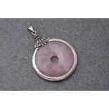 A Rose Quartz pi disc pendant with silver mount, of circular form with feathered mount and hanging