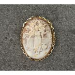 A large cameo brooch in a 9ct yellow gold setting, featuring a carving of a girl attended by