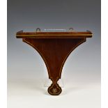 A 19th century mahogany and brass clock bracket, the shaped rectangular bracket with brass