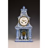 A 19th century Dutch Delft mantel clock, the top of architectural form with fleur-de-lys surmount,