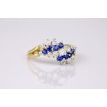 A yellow gold, diamond and sapphire ring, featuring alternating rows of undulating round brilliant