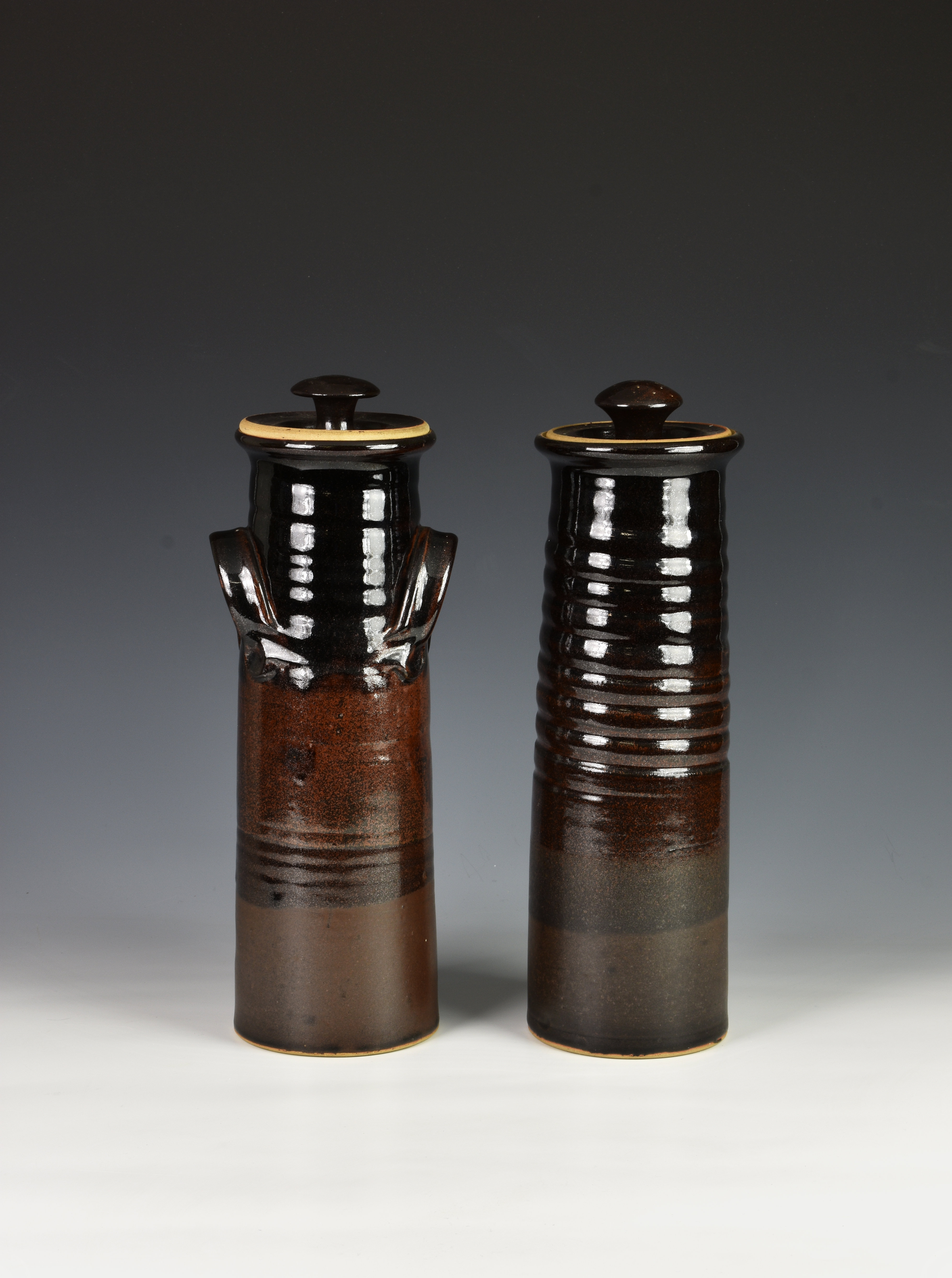 Two Guernsey pottery spaghetti storage jars, brown glazed, of similar tapering form, each printed 'C