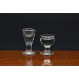 Two 19th century deceptive firing glasses, the first with cup bowl on capstan stem and plain foot,
