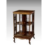 An Edwardian cross banded mahogany revolving bookcase, the tulipwood cross banded top over a two