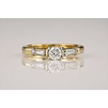 An 18ct yellow gold and diamond 3 stone ring, the central round brilliant cut diamond weighing