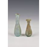 Two small Roman iridescent glass unguentariums, 1st-2nd century AD, both in very pale blue glass,