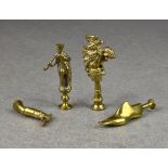 Four novelty brass pipe tampers, probably late 19th or early 20th century to include a standing