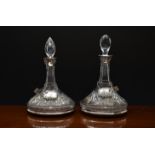 A matched pair of Elizabeth II cut glass crystal ships decanters with silver collars, silver