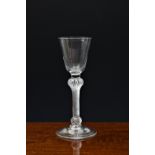 A mid-18th century air twist wine glass, c.1760, the round funnel bowl on a multiple spiral airtwist