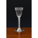 A mid-18th century engraved airtwist wine glass, c.1750-60, with floral engraved and petal moulded