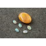 A loose orange opal and 5 smaller loose white opals (6), the larger, orange opal measuring 18mms,