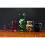 A small collection of Victorian glass jugs, including a Bohemian green glass ewer with enamel and