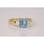 An 18ct yellow gold, aquamarine and diamond 3 stone ring, the step cut aquamarine weighing