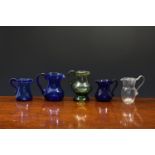 Four 18th century glass cream jugs, comprising an olive green glass bellied baluster jug with
