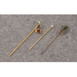 Three antique gold stick pins, comprising a 9ct horseshoe pin, a 9ct wishbone pin and an 18ct