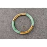 A Chinese jade and 18ct gold bangle, the gold clasp with ornate bamboo design and the jade of pale