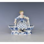 A Meissen porcelain double salt, c.1900, in the form of a girl seated upon conjoined baskets, on a