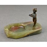 A cold painted bronze model of a Blackamoor child bearing a letter tray, standing on a dished onyx