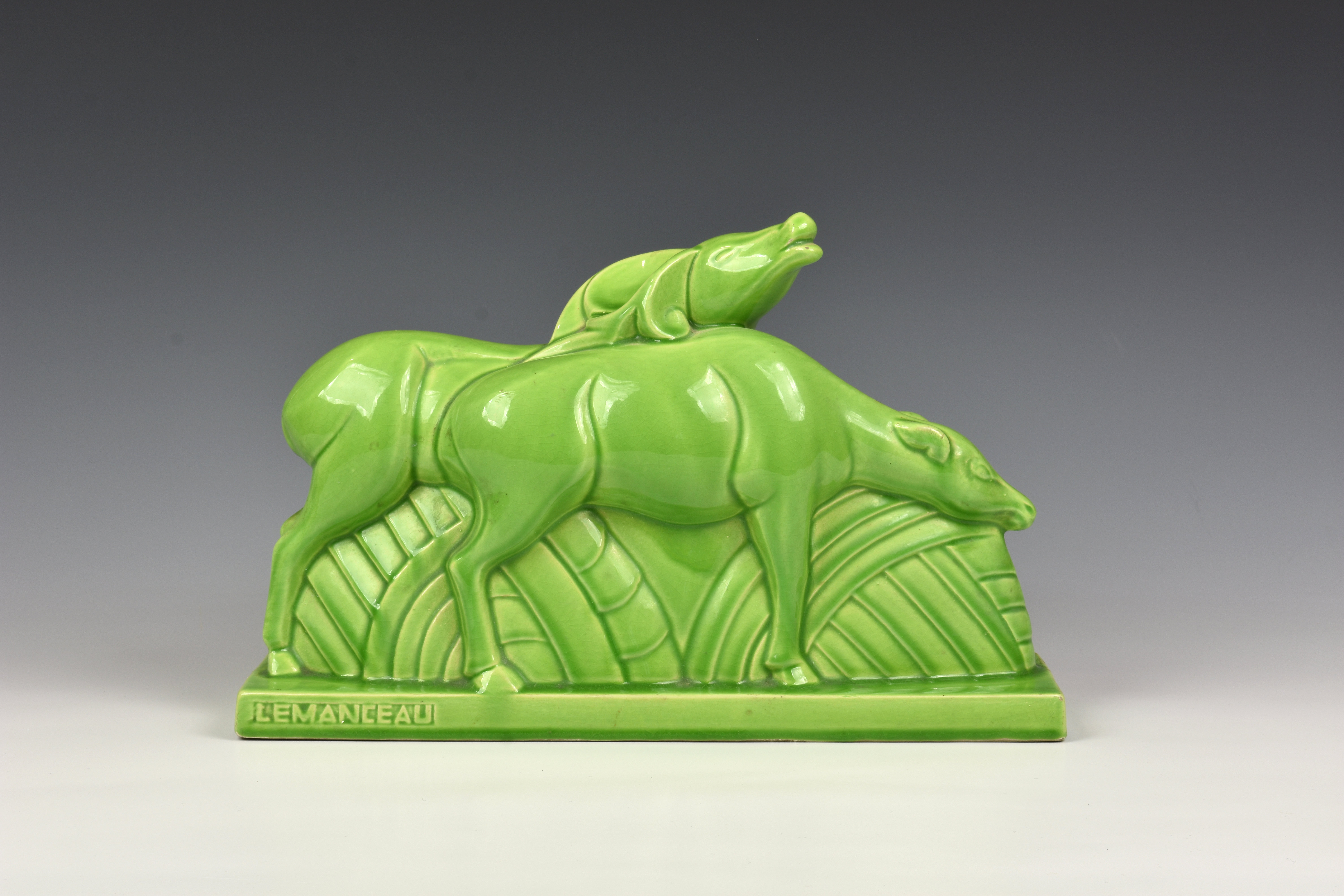 Charles Lemanceau - A French Art Deco green glazed pottery figure group of two stylized buffalo or