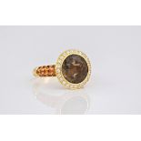 An 18ct yellow gold smoky quartz and topaz dress ring, the brilliant cut smoky quartz surrounded