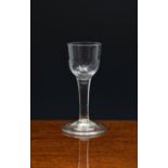 A mid-18th century fluted wine glass, c.1750, the half fluted ogee bowl with slightly tapered