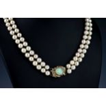 A two strand cultured pearl necklace with 14ct gold, opal and diamond clasp, with 7mm. pearls, the