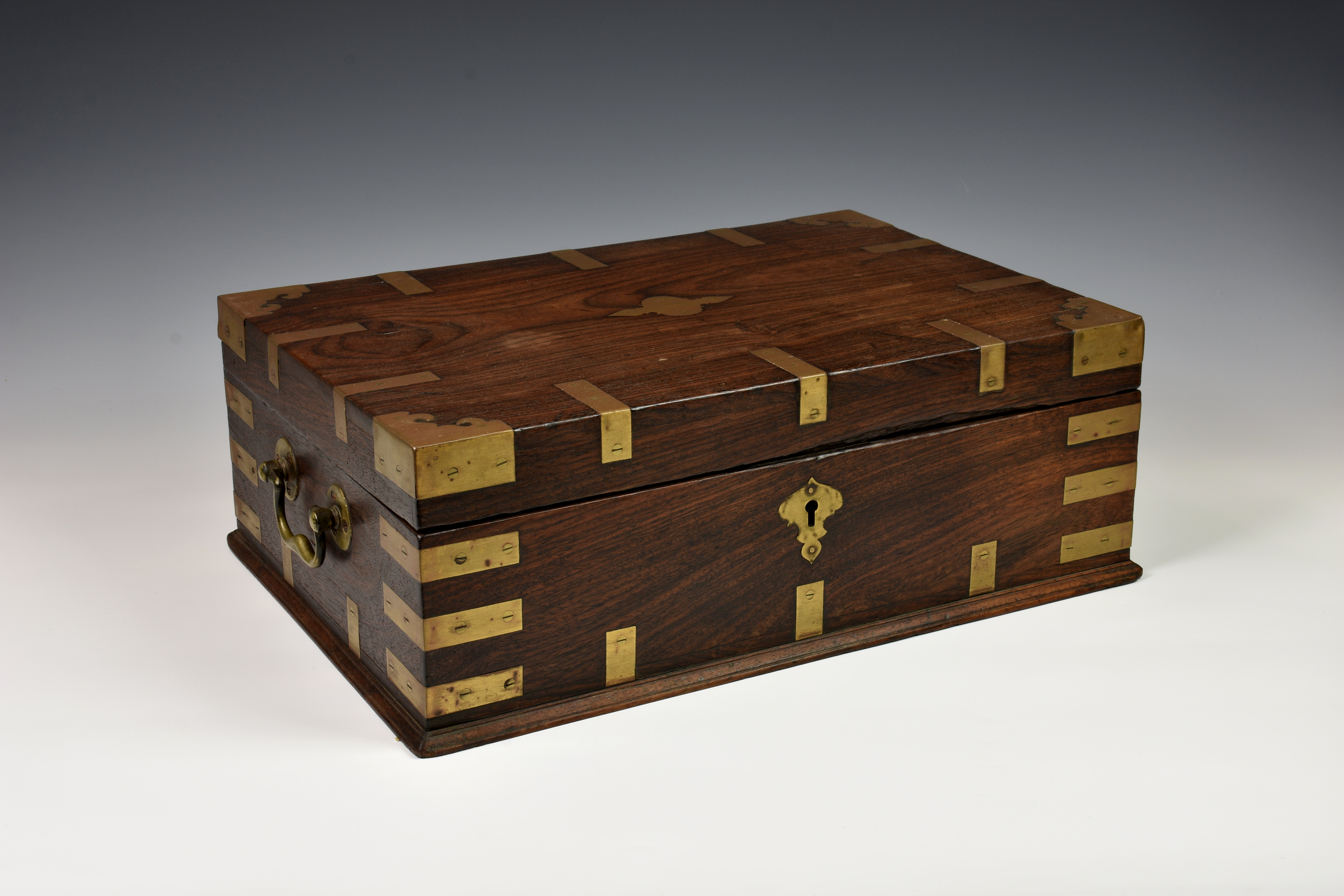 An Anglo Indian rosewood and brass bound stationary box, c.1900, the hinged lid opening to reveal
