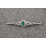 An Art Deco style platinum, diamond and emerald brooch, the central step cut emerald of deep,
