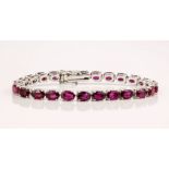 An 18ct white gold and ruby line bracelet, the rubies totalling approximately 19ct, of deep red to