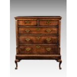 A George III provincial oak chest on stand, the mahogany cross banded flared top over two short