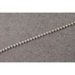 An 18ct white gold and diamond line bracelet, containing 33 brilliant cut diamonds in rub over