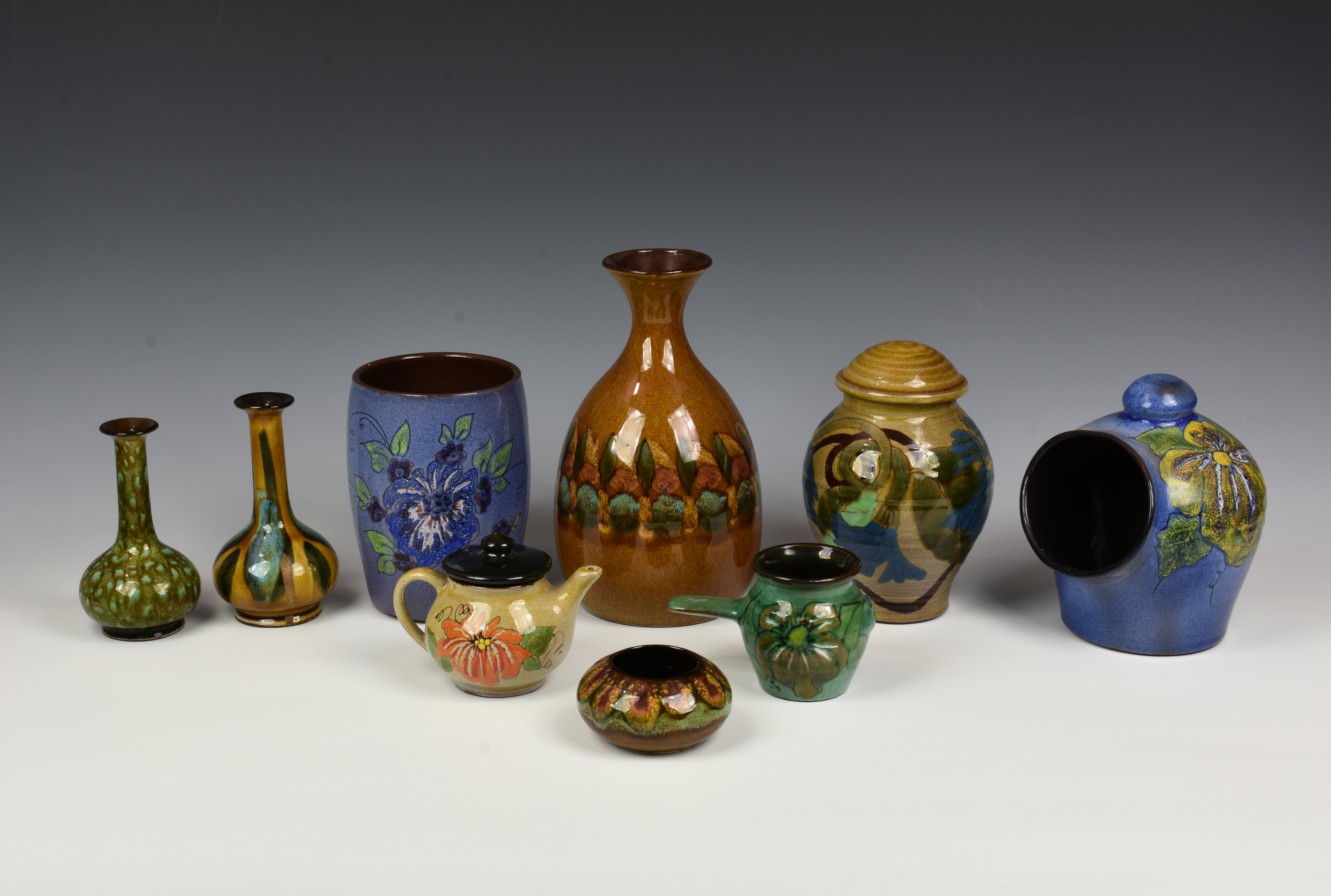 A large collection of Guernsey Pottery, decorated with floral or stylised designs on blue, green and