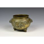 A Chinese bronze dragon censer, of circular form, with bulbous body applied with twin lion-head