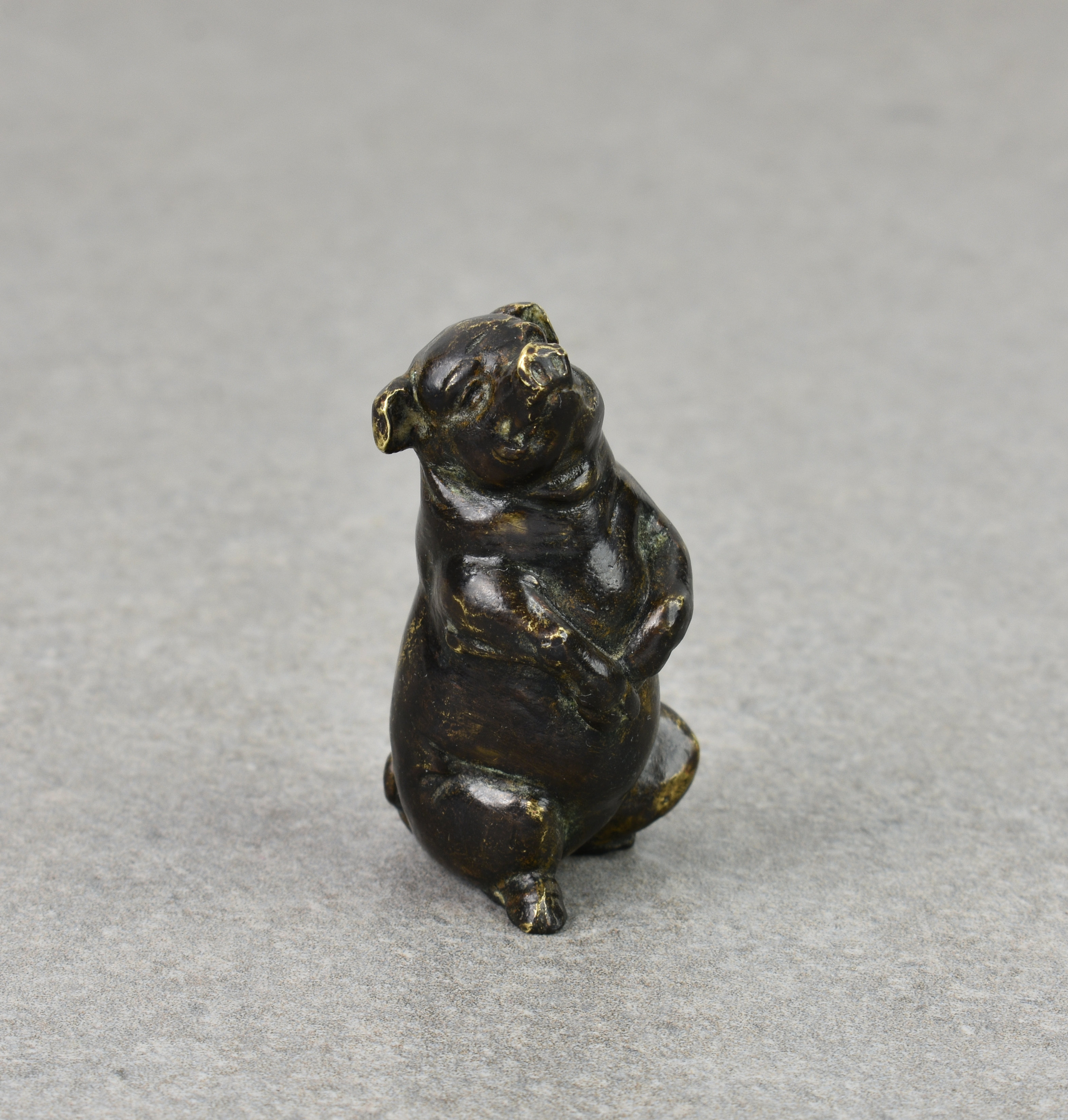 A miniature patinated bronze seated pig, probably early 20th century, the seated pig with a very