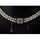 A double row cultured pearl necklace with an antique diamond and sapphire inset clasp, the clasp