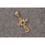 A 14ct yellow gold cross pendant, with ornate detailing to the metal. A cabochon emerald is set to