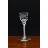 A mid-18th century Jacobite engraved airtwist wine glass, c.1750-60, with rose and insect engraved