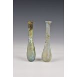 Two Roman iridescent glass unguentariums, 1st-2nd century AD, one in clear glass, with a flat,