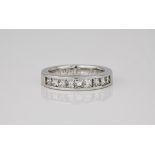 A platinum and diamond half eternity ring, the channel set princess cut diamonds totalling