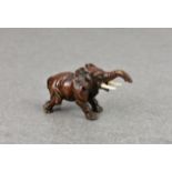 A miniature patinated bronze elephant figure, possibly Japanese, early 20th century, standing with